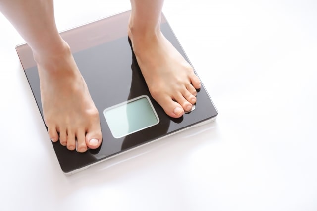 ケトジェニックダイエット中に体重計に乗る女性